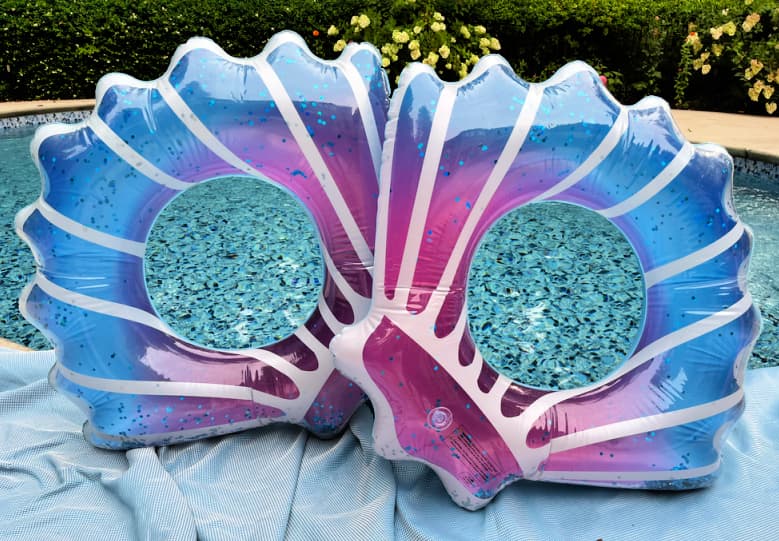 two blue and purple pool floats shaped like shells