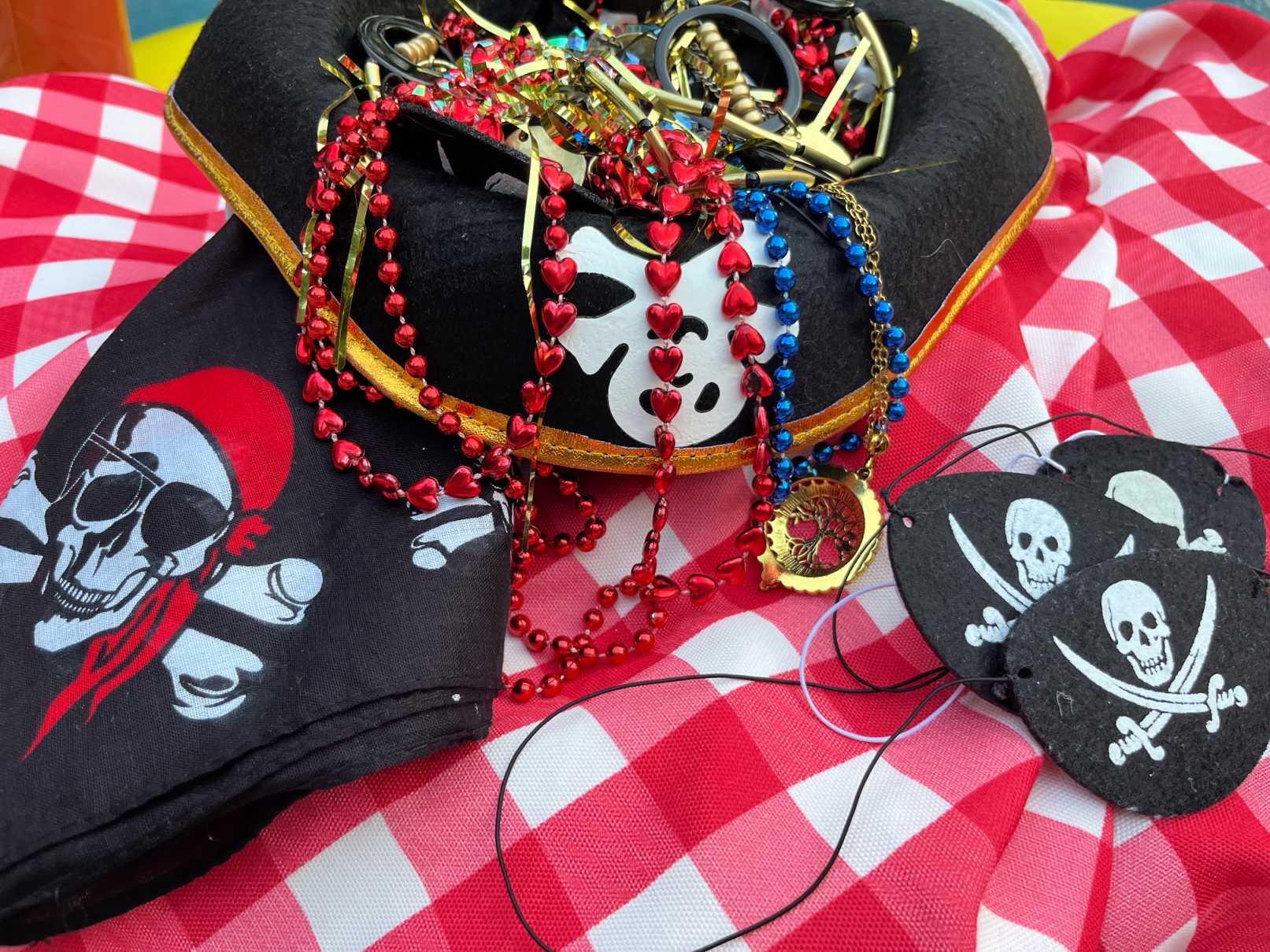 pirate hat filled with jewelry and pirate eye patches and bandanas
