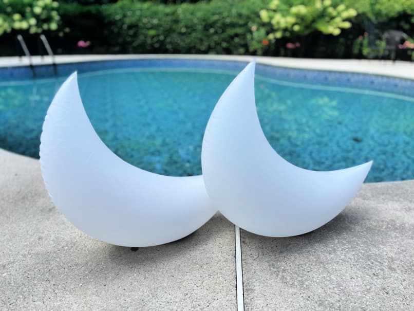 two crescent moon shaped floating pool lights