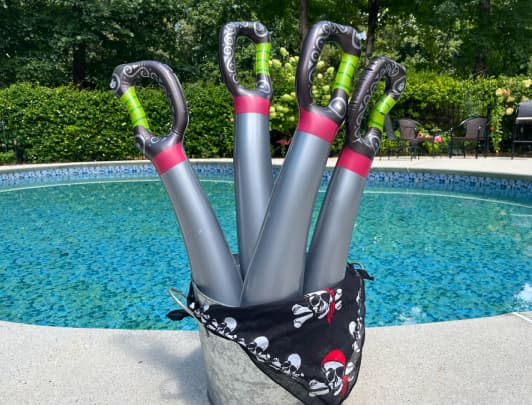 4 inflatable pirate swords by swimming pool