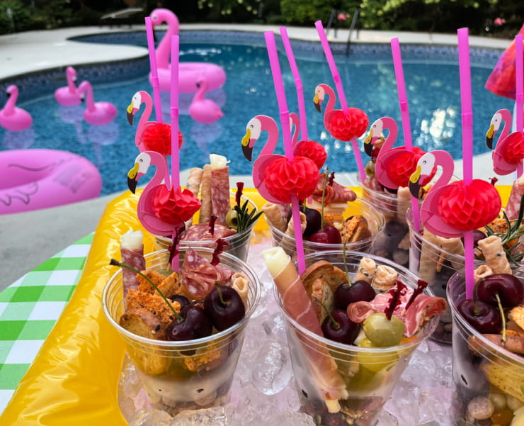 charcuterie board in cups served on ice in an inflatable salad bar
