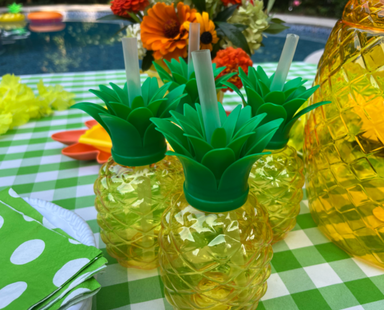 3 pineapple shaped pool party cups on a Hawaiian themed pool party table setting