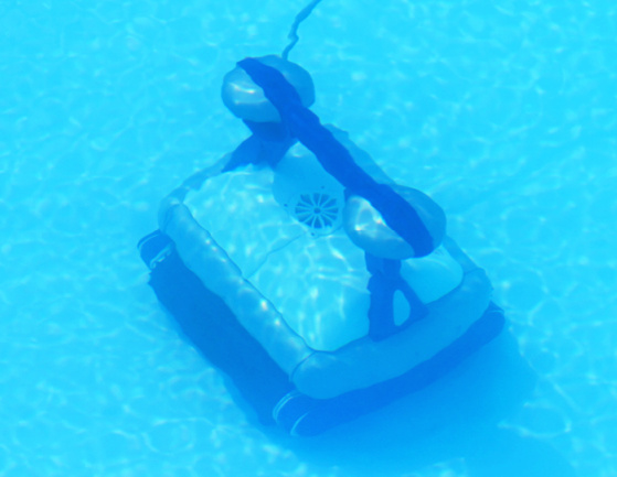 robotic pool cleaner on the bottom of an inground pool